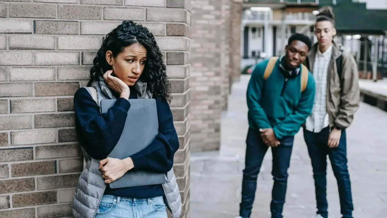 Ein Mädchen fühlt sich unwohl, als zwei Jungen sie anstarren. Eine Szene, die an eine **kurzgeschichte mobbing grundschule** erinnert, wo Ausgrenzung und Angst herrschen.