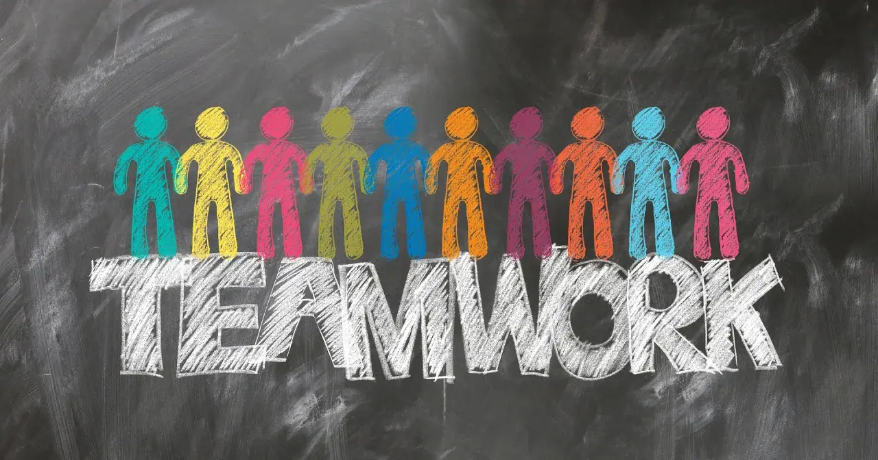 Bunte Figuren stehen auf dem Wort TEAMWORK. Tolle Ideen für die Klassenlehrerstunde, die Zusammenarbeit fördern.