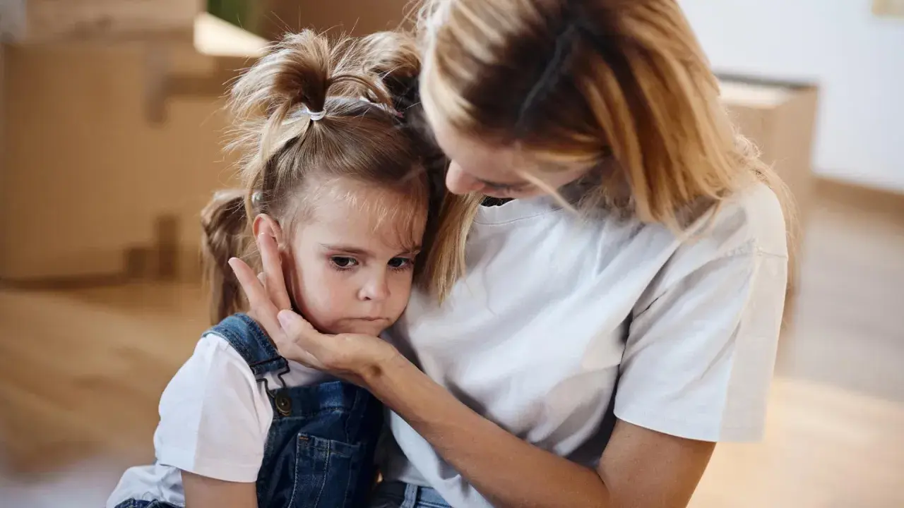 Mutter tröstet ihr Kind, das Angst vor anderen Kindern hat.