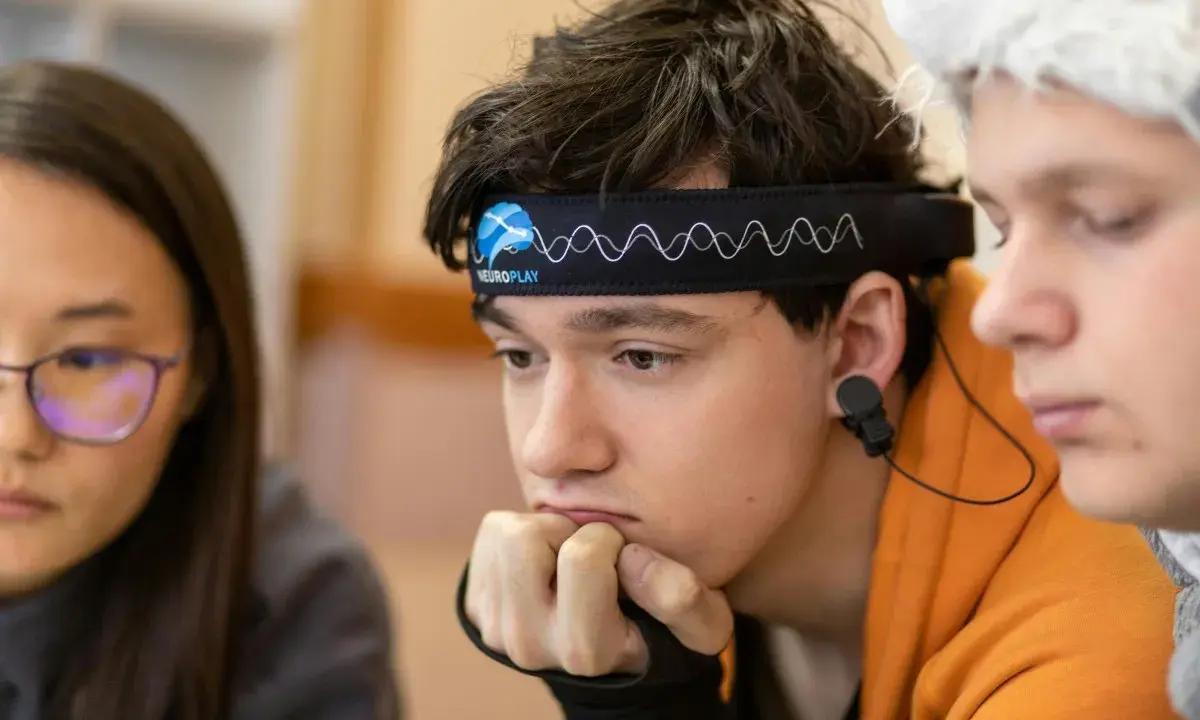 Junge mit Neurofeedback-Band am Kopf, der konzentriert nachdenkt. Positive Neurofeedback-Erfahrungen bei ADHS-Kindern sind möglich.
