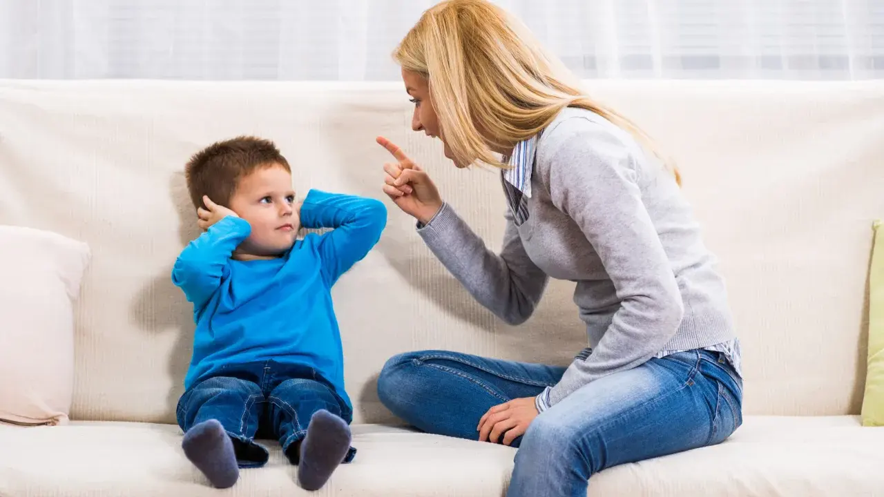 Mutter schimpft mit Sohn, der sich die Ohren zuhält. Ein typischer Streit mit Eltern, der die Geduld auf die Probe stellt.
