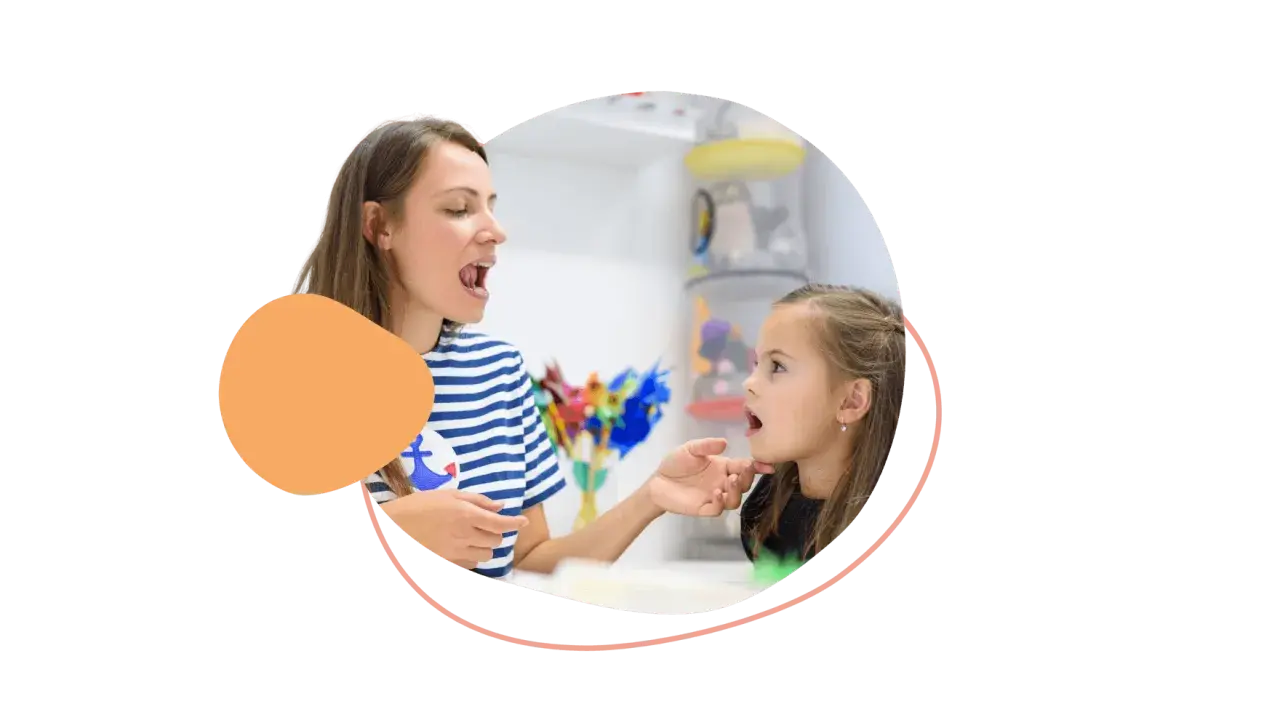 Logopädin zeigt einem Mädchen, wie man Laute richtig formt. So lernen Kinder am besten neue Sprechfähigkeiten.
