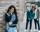 Ein Mädchen fühlt sich unwohl, als zwei Jungen sie anstarren. Eine Szene, die an eine **kurzgeschichte mobbing grundschule** erinnert, wo Ausgrenzung und Angst herrschen.