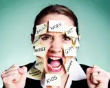 Überforderte Frau mit Zetteln wie "Work", "Bills", "Kids". Sie kämpft, um ihre Wut zu kontrollieren und Selbstbeherrschung zu lernen.