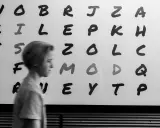 Junge vor Buchstabenwand, die LRS-Symptome in der 2. Klasse verdeutlichen könnte.