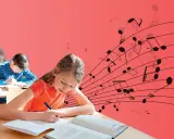 Mädchen schreibt im Unterricht, während Noten über ihr schweben. Musik und Unterricht vereinen sich.