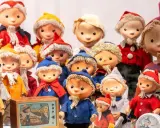 Eine Sammlung von Sandmann-Charakteren in bunten Kostümen, einige mit Bart und Mützen, stehen dicht gedrängt.