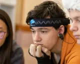 Junge mit Neurofeedback-Band am Kopf, der konzentriert nachdenkt. Positive Neurofeedback-Erfahrungen bei ADHS-Kindern sind möglich.