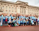 Eine fröhliche Gruppe Jugendlicher vor dem Buckingham Palace, bereit für ihr sprachcamp englisch.