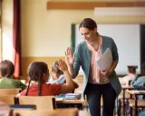 Lehrerin gibt einem Grundschüler einen High-Five. So kann man Kinder zum Lernen motivieren.