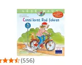 Conni lernt Rad fahren: Ein Mädchen mit Helm fährt stolz auf ihrem roten Fahrrad, ein Teddy im Korb, eine Katze rennt daneben.