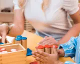 Ein Kind spielt mit Holzbausteinen. Die Frage, ab wann man Autismus diagnostizieren kann, ist komplex und hängt von vielen Faktoren ab.