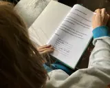 Kind macht Hausaufgaben und löst ein Eichhörnchen-Rätsel.