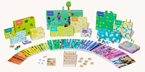 Bunte Lernspiele und Karten fördern spielerisch lesen lernen. Kleine Holzfiguren und bunte Boxen laden zum Entdecken ein.