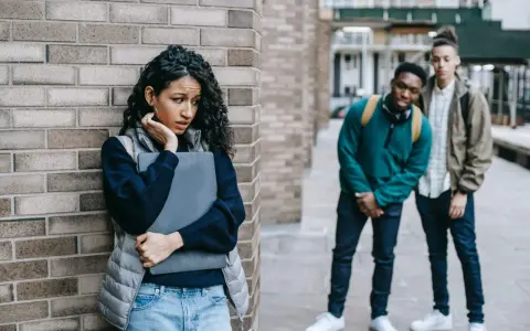Ein Mädchen fühlt sich unwohl, als zwei Jungen sie anstarren. Eine Szene, die an eine **kurzgeschichte mobbing grundschule** erinnert, wo Ausgrenzung und Angst herrschen.