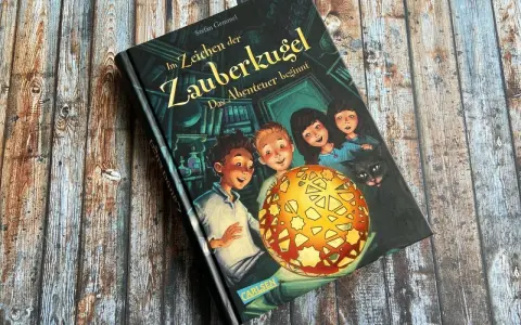 Ein Buchcover mit dem Titel "Im Zeichen der Zauberkugel". Kinder und eine Katze blicken neugierig auf eine leuchtende Kugel.