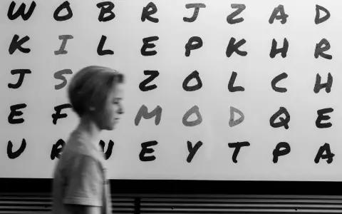 Junge vor Buchstabenwand, die LRS-Symptome in der 2. Klasse verdeutlichen könnte.