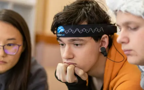 Junge mit Neurofeedback-Band am Kopf, der konzentriert nachdenkt. Positive Neurofeedback-Erfahrungen bei ADHS-Kindern sind möglich.