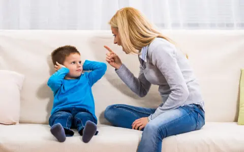 Mutter schimpft mit Sohn, der sich die Ohren zuhält. Ein typischer Streit mit Eltern, der die Geduld auf die Probe stellt.