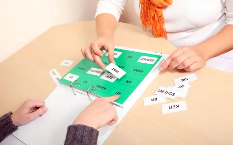 Therapeuten üben mit Karten, um die Ursachen von Lernbehinderungen zu verstehen. Wörter wie "HAT", "TRAURIG" und "HAAR" werden sortiert.