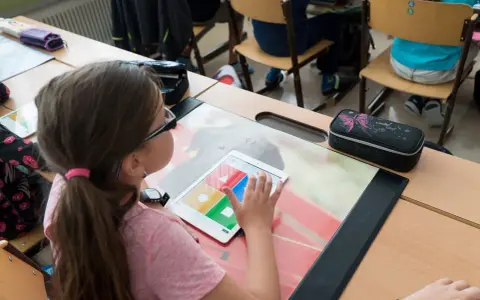 Ein Mädchen nutzt ein Tablet im Unterricht. Digitale Medien im Unterricht machen das Lernen interaktiv und spannend.