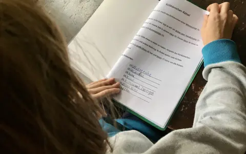 Kind macht Hausaufgaben und löst ein Eichhörnchen-Rätsel.