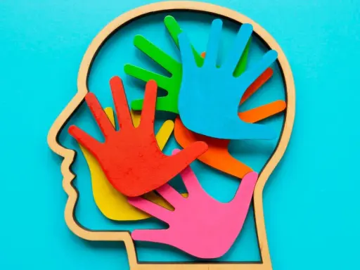 Bunte Hände im Kopfprofil symbolisieren die Vielfalt der Wahrnehmung. Wer stellt Autismus fest? Fachleute mit Verständnis für diese neurologische Besonderheit.