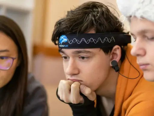 Junge mit Neurofeedback-Band am Kopf, der konzentriert nachdenkt. Positive Neurofeedback-Erfahrungen bei ADHS-Kindern sind möglich.