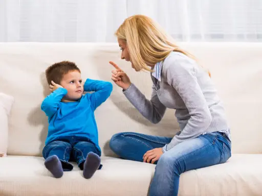 Mutter schimpft mit Sohn, der sich die Ohren zuhält. Ein typischer Streit mit Eltern, der die Geduld auf die Probe stellt.