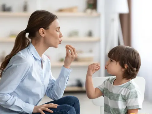 Eine Frau und ein Kind machen Lippenbewegungen. Dies kann ein Hinweis sein, um autismus erkennen kind.