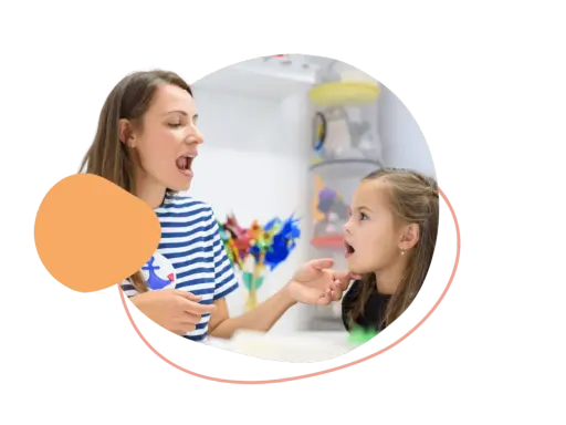 Logopädin zeigt einem Mädchen, wie man Laute richtig formt. So lernen Kinder am besten neue Sprechfähigkeiten.