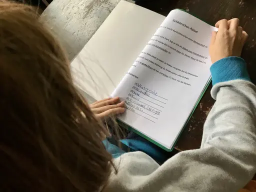 Kind macht Hausaufgaben und löst ein Eichhörnchen-Rätsel.
