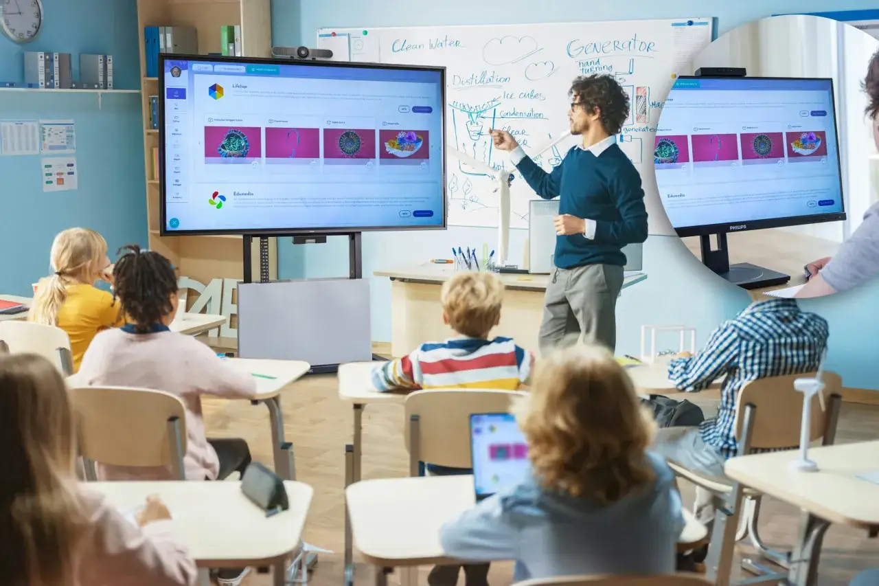 Lehrer erkl&auml;rt am Whiteboard, w&auml;hrend Sch&uuml;ler im hybrid unterricht auf Bildschirme schauen.