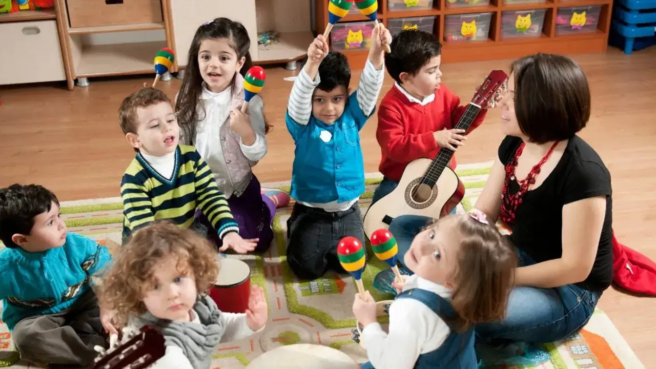 Kinder lernen Musik und Rhythmus im Unterricht mit Instrumenten wie Gitarre und Maracas.