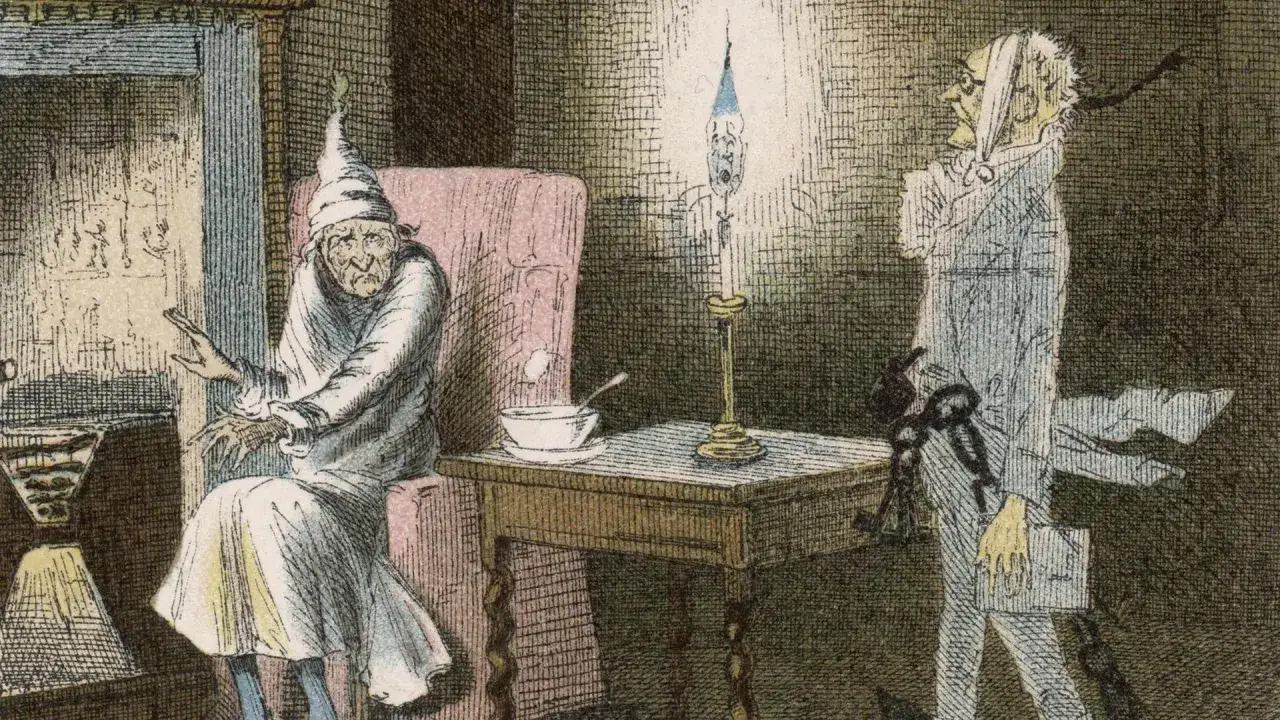 Ebenezer Scrooge sitzt im Sessel, während der Geist von Jacob Marley mit Ketten erscheint. Eine Szene aus Charles Dickens' Weihnachtsgeschichte.