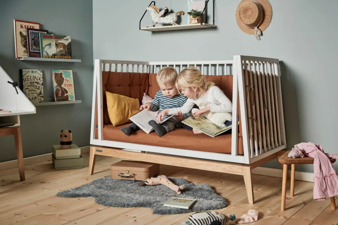 Zwei Kinder sitzen in einem Bett und lesen. Ein Junge und ein M&auml;dchen, die gemeinsam lesen mit Kindern genie&szlig;en, vertieft in ihre B&uuml;cher.