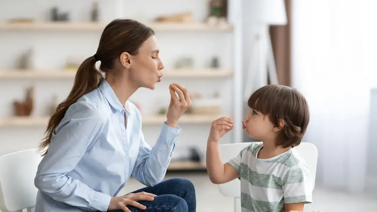 Therapeutin &uuml;bt mit 4-j&auml;hrigem Kind, um Autismus-Symptome zu erkennen. Sie machen Lippenbewegungen, um die Kommunikation zu f&ouml;rdern.