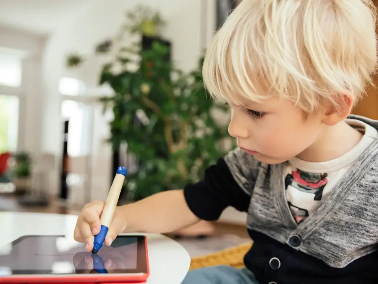 Ein Junge lernt mit einer Rechtschreibung lernen App auf seinem Tablet.