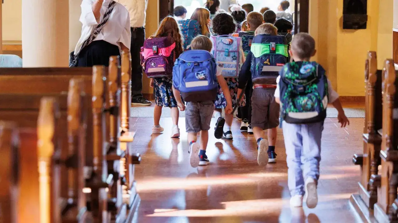Kinder mit bunten Schulranzen gehen auf dem Gang. Ein guter Start in der neuen Schule beginnt mit Vorfreude und neuen Abenteuern.