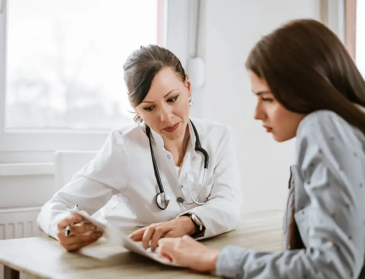 Ärztin bespricht mit Patientin Unterlagen, die zeigen, wer ADHS diagnostiziert.