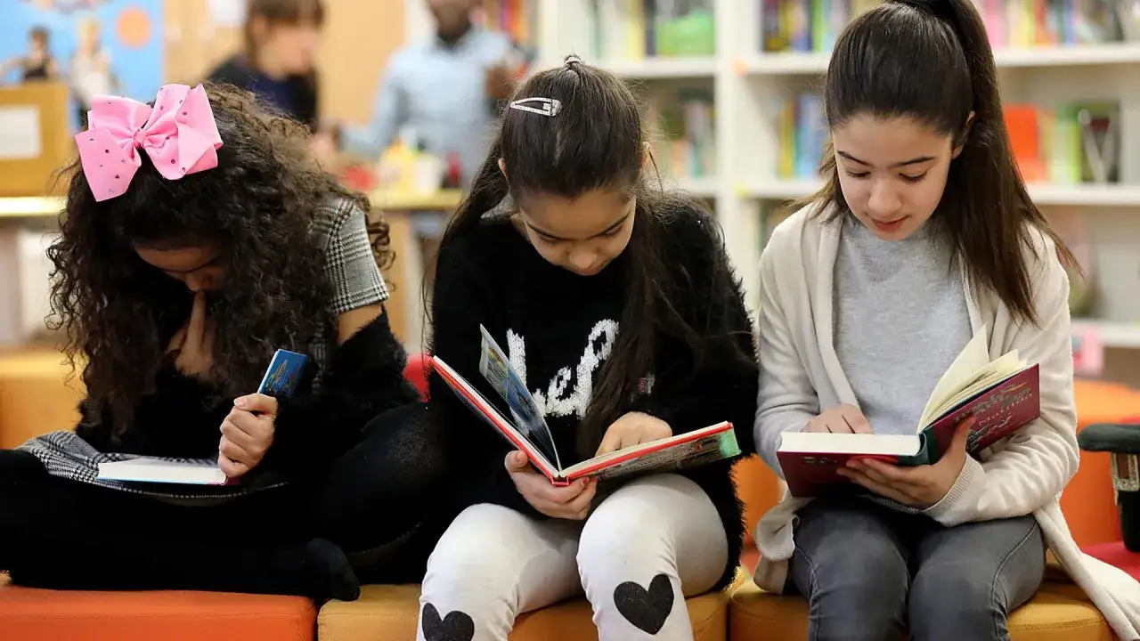 Drei M&auml;dchen lesen konzentriert B&uuml;cher. Ihre Lesegeschwindigkeit durchschnitt ist wahrscheinlich hoch, da sie vertieft sind.