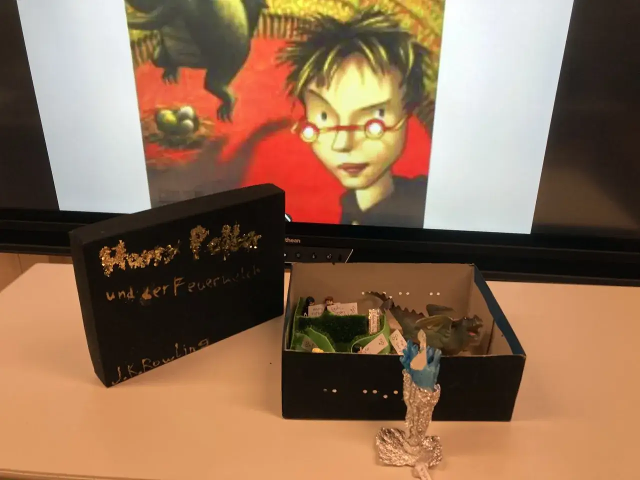 Harry Potter Buchvorstellung: Diorama mit Drachen, Harry, Cedric und Zauberstab.